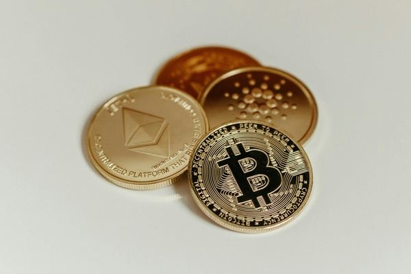 Bitcoin, Ethereum and Cardano coins on a white surface