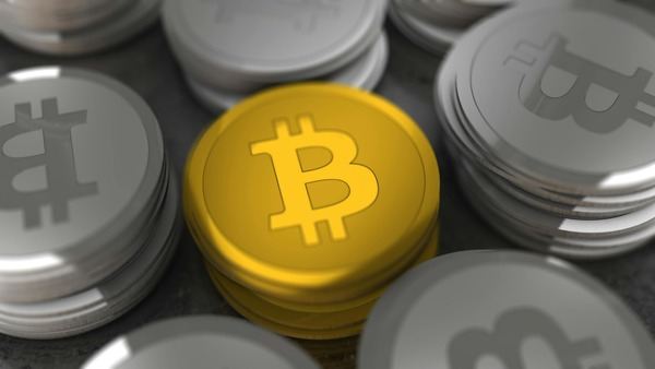 Gold Bitcoin coin surrounded by stacks of silver coins