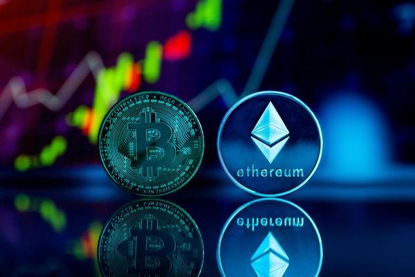 Bitcoin and Ethereum coins reflected in front of a glowing price chart