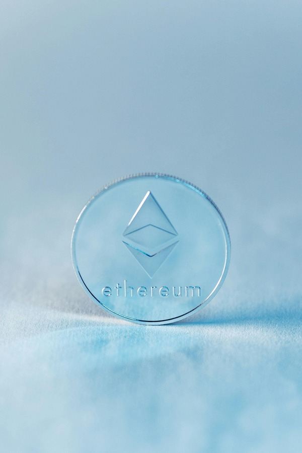 Translucent Ethereum coin standing on an icy blue surface