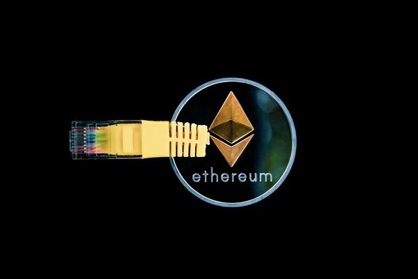 Ethereum coin connected to a yellow network cable on a black background