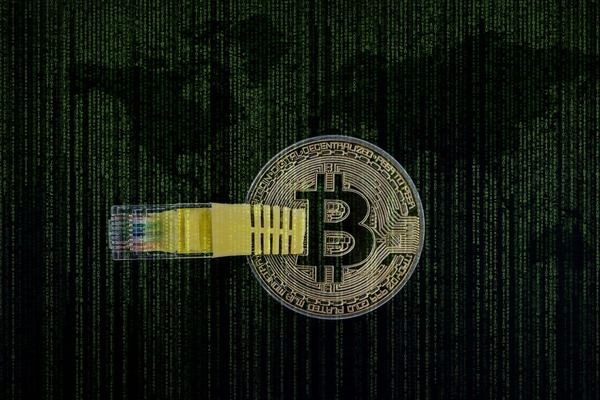 Bitcoin coin with a network cable over a green matrix code background