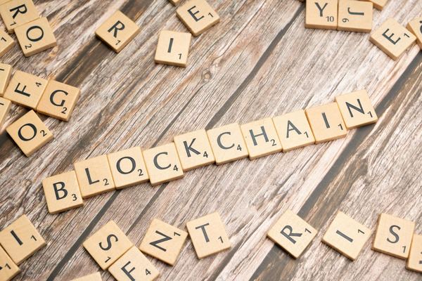 Wooden letter tiles spelling blockchain on a wooden table